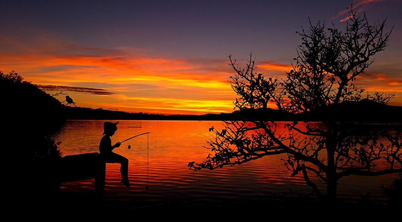 child fishing in lake