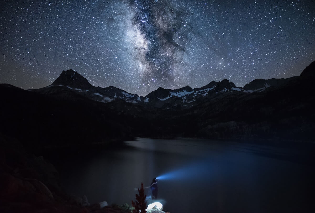 man standing in hills at night